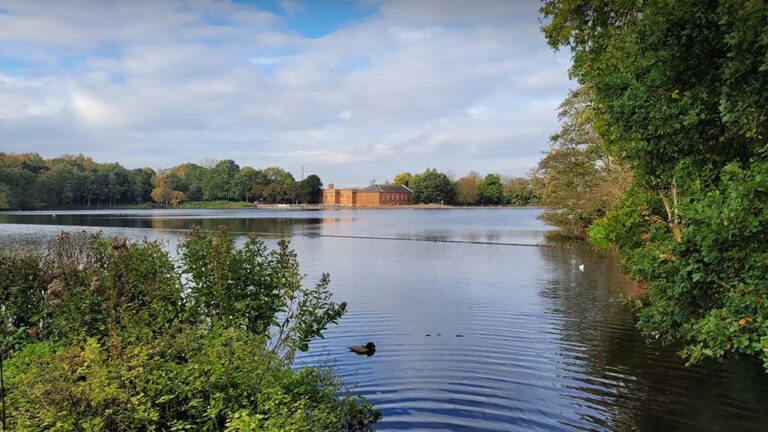 a panoramic view of rufford mill across the lake